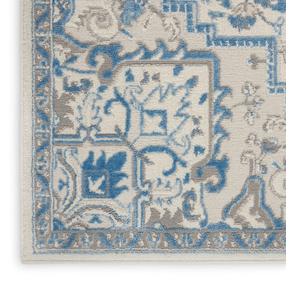 Blue and beige Oriental rug corner with fringe; woven floral and geometric border.