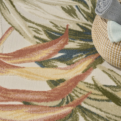 Close-up of a textured cream rug with leaf-like pattern in green, yellow, rust beside a woven rattan basket with striped fabrics.