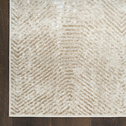 Neutral beige tufted rug with chevron pattern, rectangular on dark wood floor; cozy plush texture.