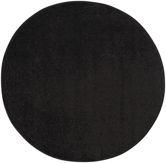 Round black felt circle with textured surface, minimalist placemat.