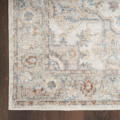 Cream and blue distressed oriental area rug with tan and rust border accents on dark wood floor.