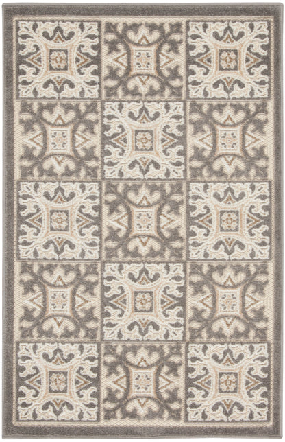 Rectangular neutral-toned area rug with cream and taupe tiled square motifs, ornate scrollwork, plush textured weave.
