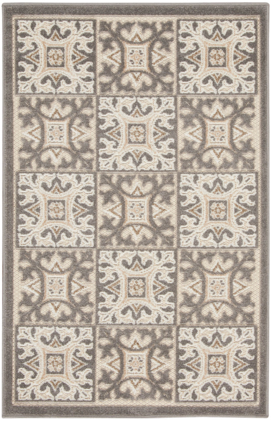 Rectangular neutral-toned area rug with cream and taupe tiled square motifs, ornate scrollwork, plush textured weave.