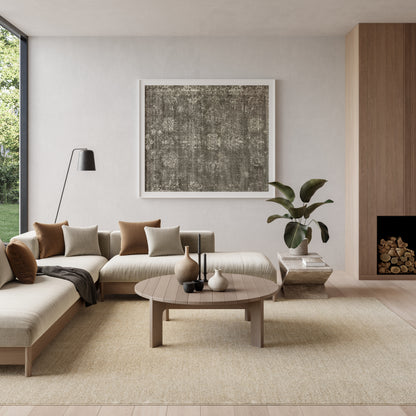 Neutral living room with beige sectional, round wood coffee table, rug, framed dark abstract art, plant, floor lamp.