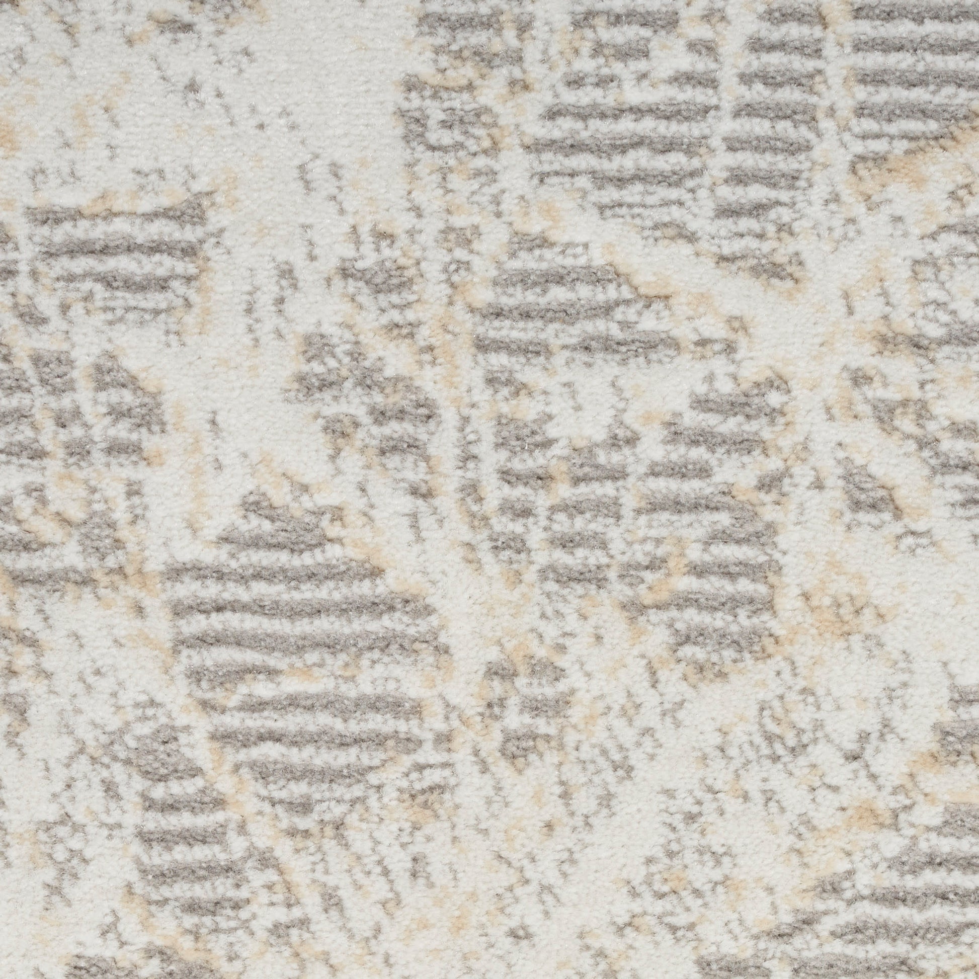 Close-up of a beige-gray geometric rug with tan accents and plush texture.