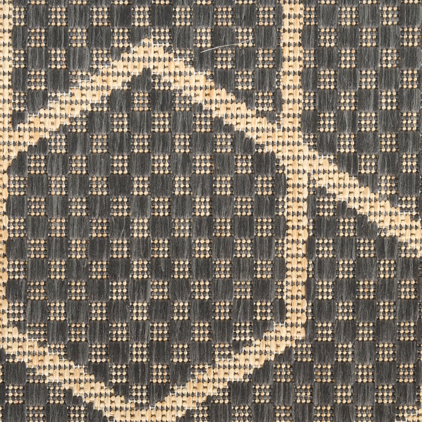 Close-up of dark navy and beige woven fabric with circular geometric motif; textured jacquard for upholstery or rug.