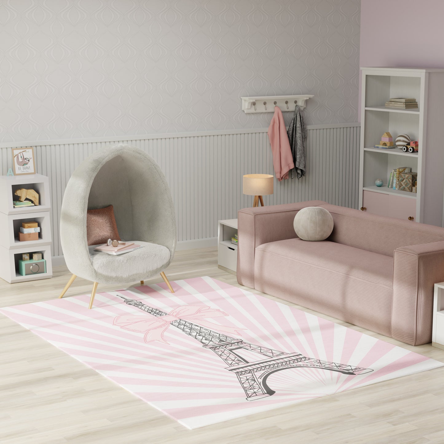 Pastel kids' living room with pink sofa, round grey lounge chair, & pink Eiffel Tower rug.
