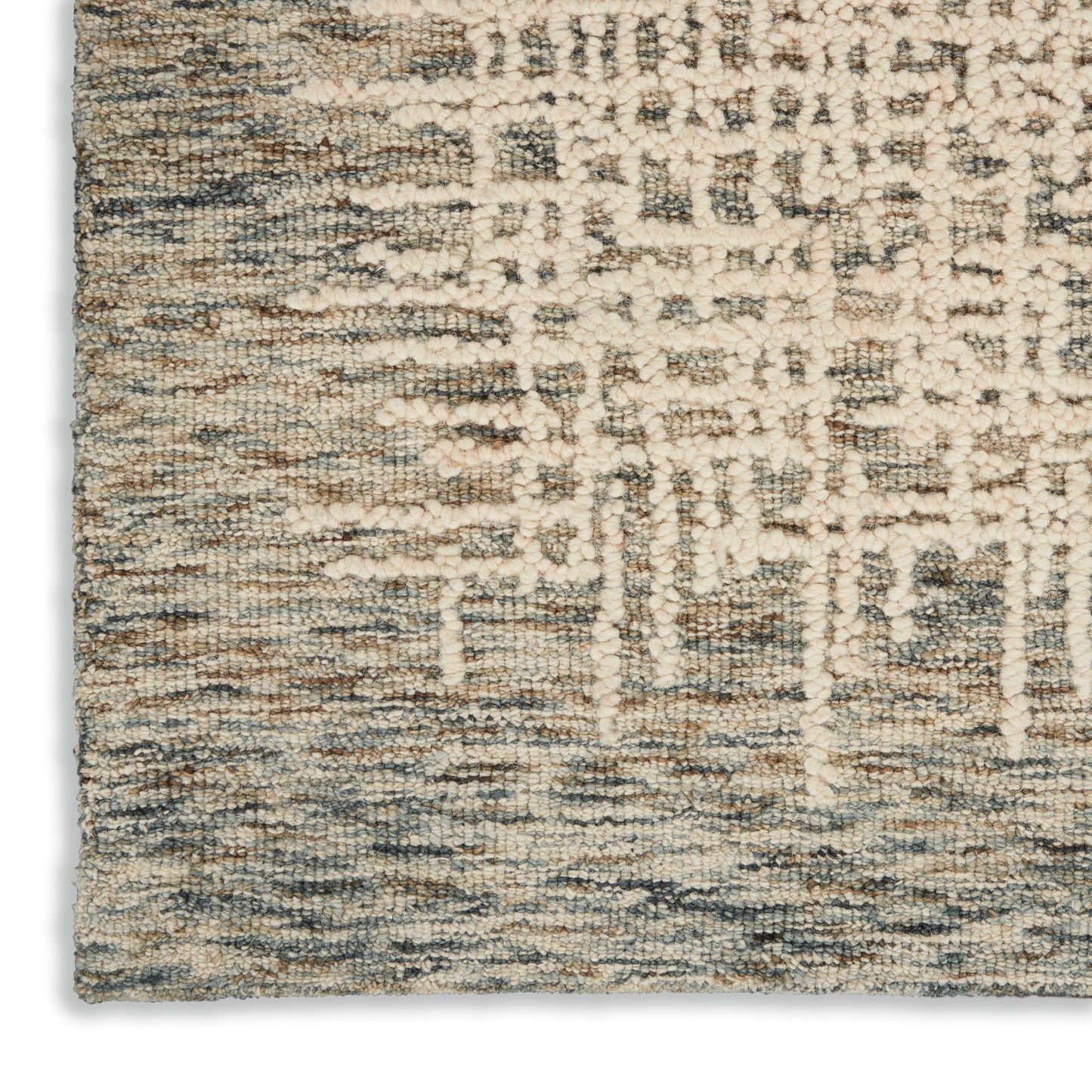 Beige, cream and blue woven rug with abstract vertical pattern; dense loop-pile texture, close-up corner.