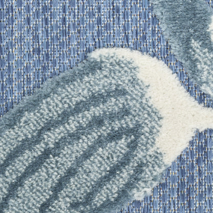 Close-up of a blue-gray plush shag rug with cream fringe, highlighting soft texture and geometric rectangular pattern.
