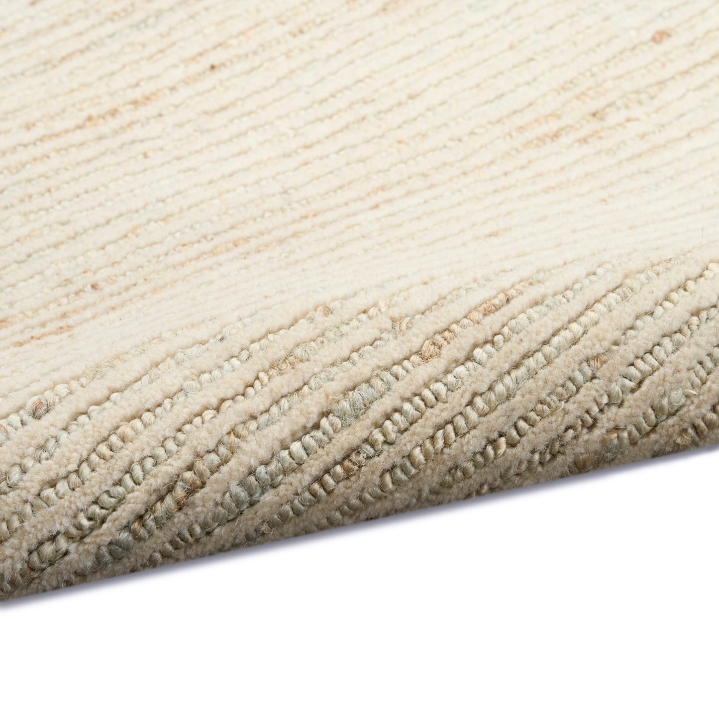 Cream-colored textured rug with soft, looped pile & bound edge; close-up of corner.