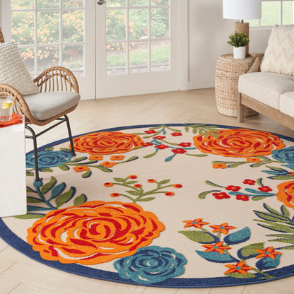 Round floral rug with orange roses, blue accents and green leaves, featuring a dark blue border in a bright living room.