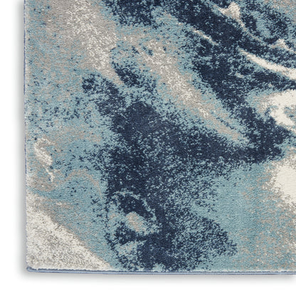 Abstract blue and cream area rug with navy, light blue, ivory marbled pattern and textured pile.