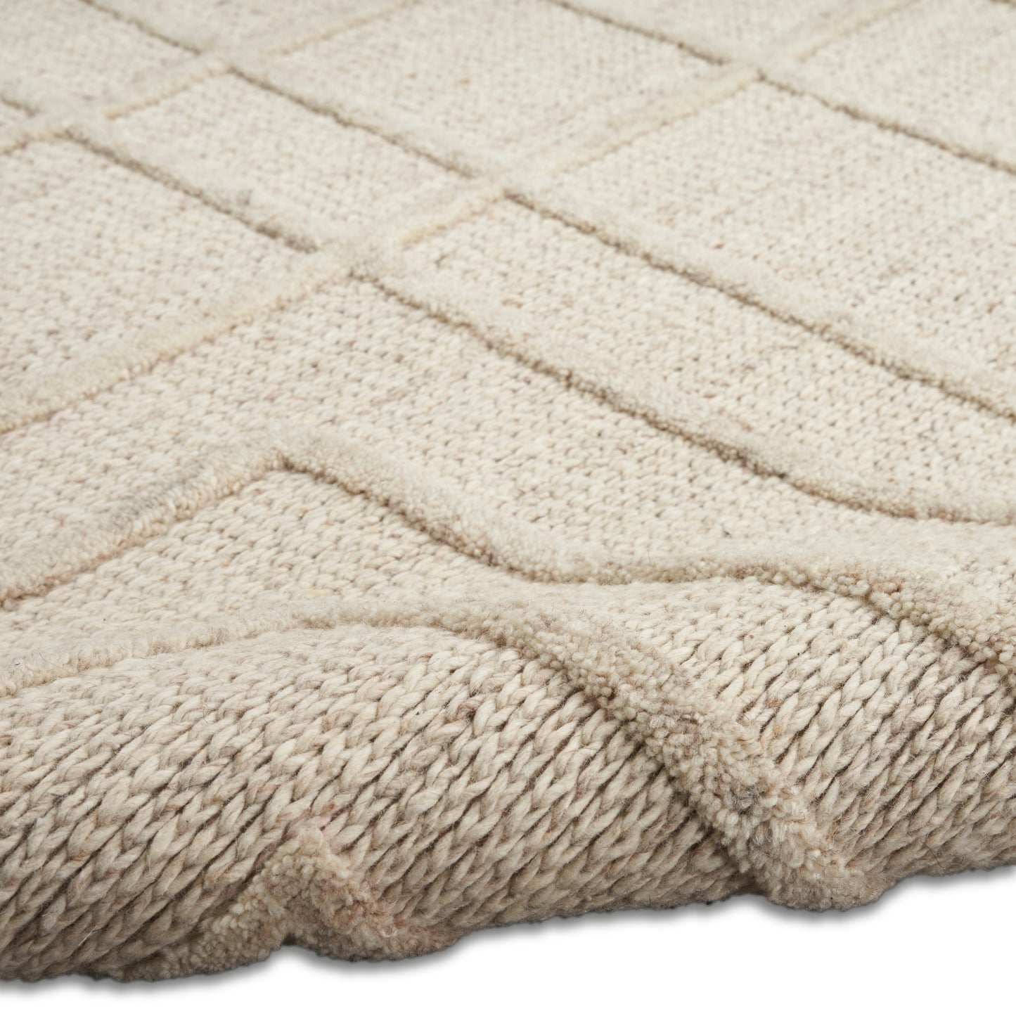 Beige textured rug with geometric raised chevron pattern and a thick braided edge, wool blend.