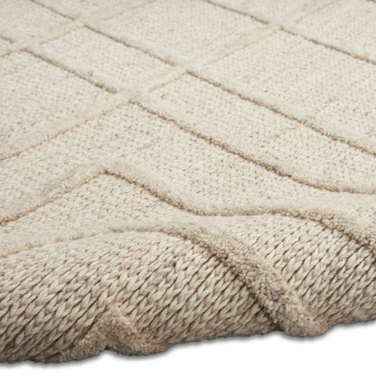 Beige textured rug with geometric raised chevron pattern and a thick braided edge, wool blend.