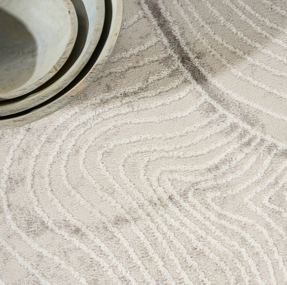Beige tufted rug with white wavy lines; shallow ceramic bowls in pale blue-gray tones.