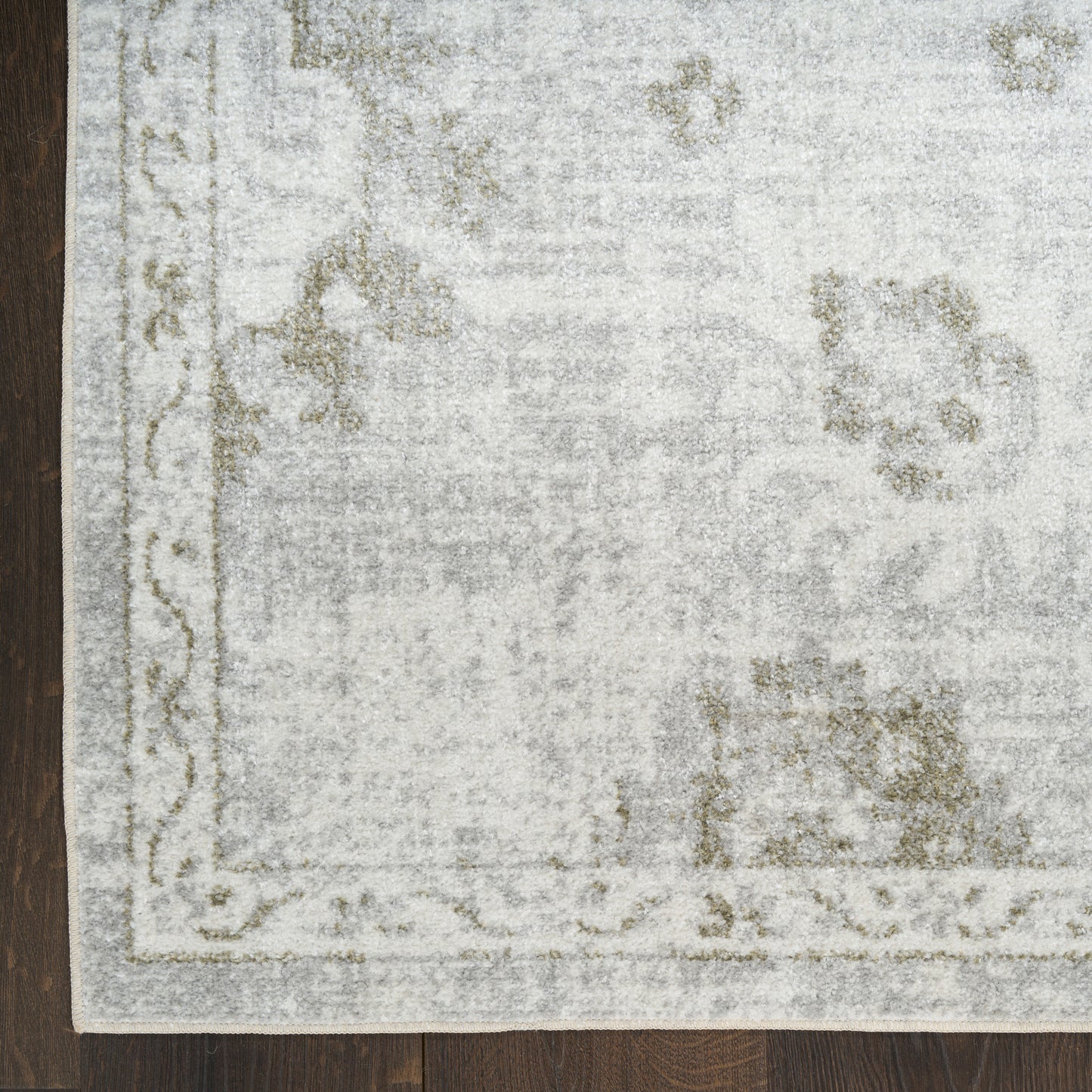 Rectangular pale gray vintage-style 6' runner rug with a light floral border on a dark wooden floor.