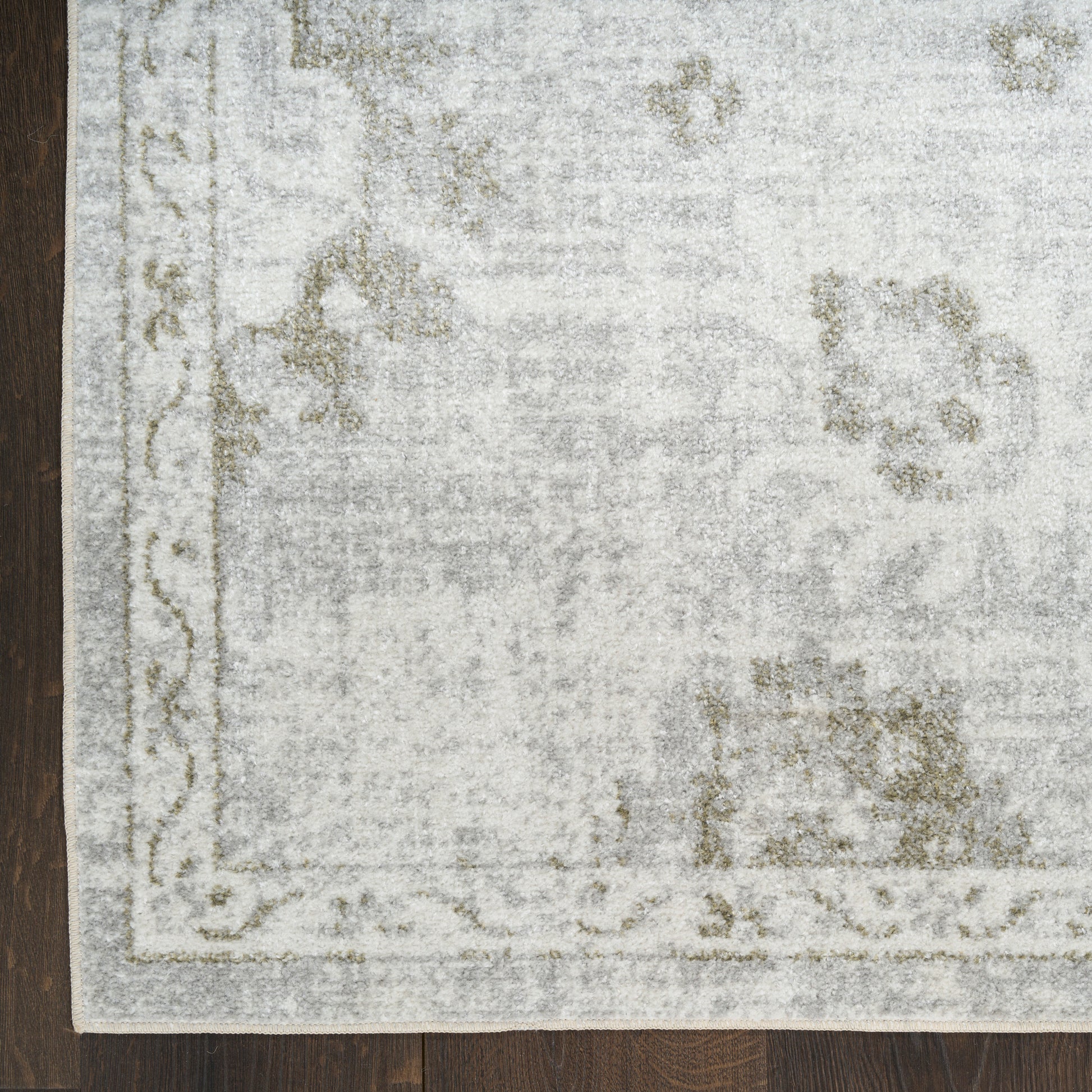 Rectangular pale gray vintage-style 6' runner rug with a light floral border on a dark wooden floor.