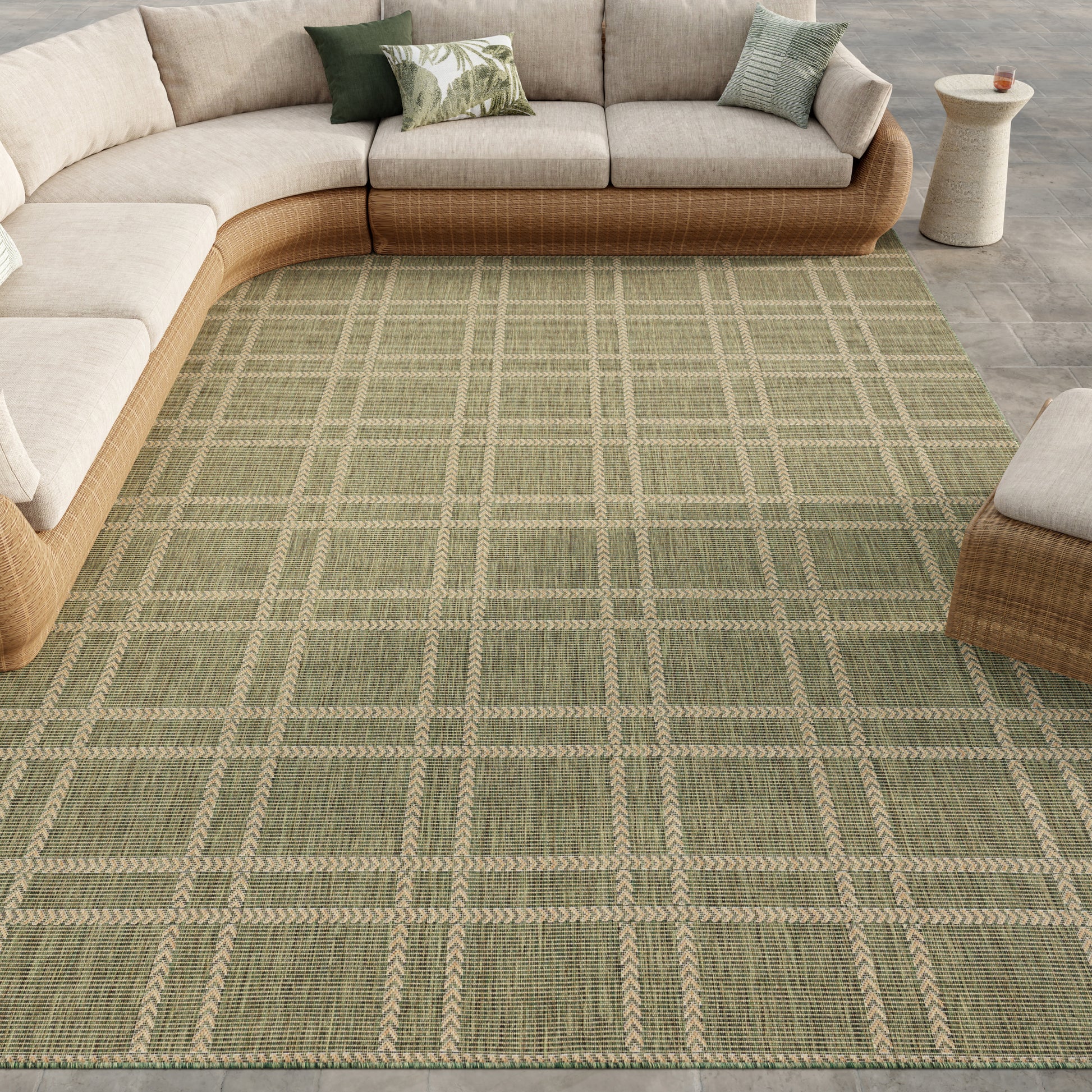 Olive-green woven area rug with beige grid under a curved beige sectional in a modern living room.