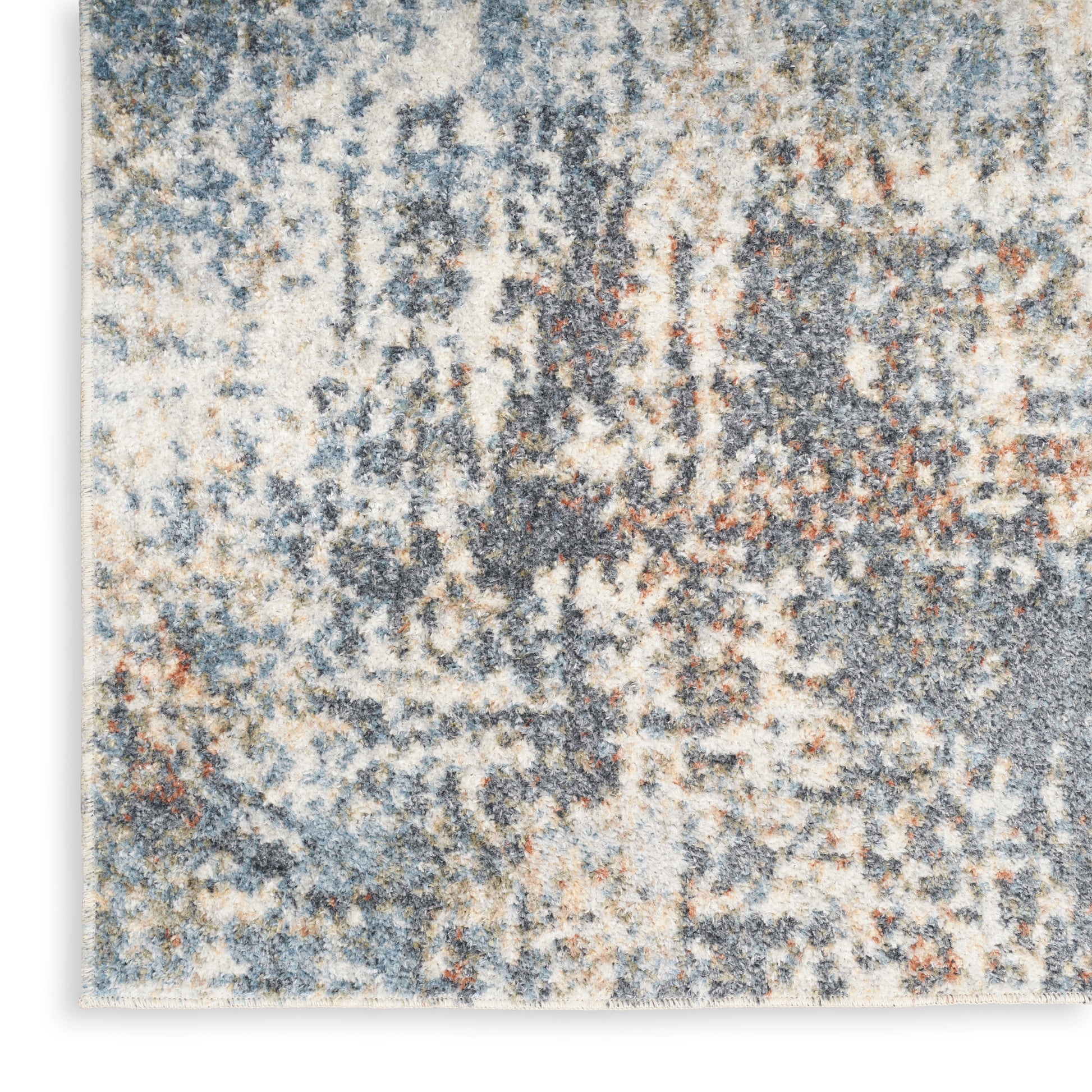 Rectangular abstract area rug in blue, beige, gray & rust with a distressed pattern & soft plush pile.