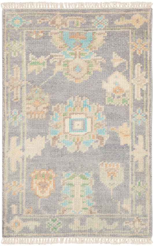 Lavender-gray woven rug with pastel cream, peach and turquoise floral medallions and fringed edges.