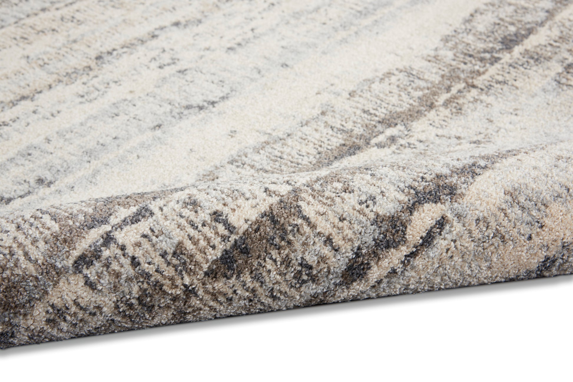 Soft beige and taupe woven rug with gray abstract pattern and thick plush pile, folded edge.