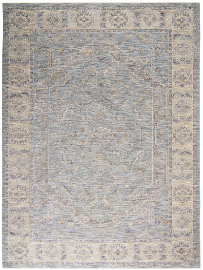 Muted blue-gray oriental rug with ivory border and faded floral medallions, vintage distressed look.