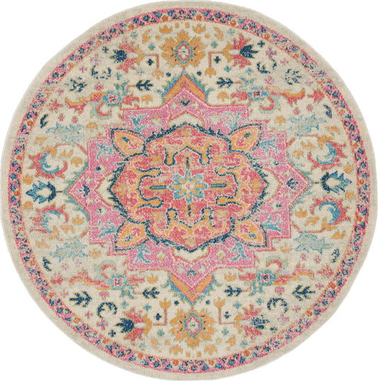 Round boho rug with cream backdrop and a pink central medallion, teal, coral and yellow florals, ornate border pattern.
