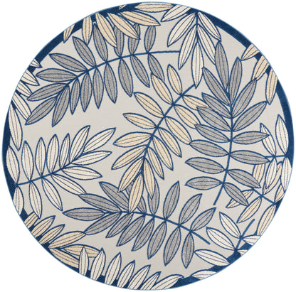Round rug with navy and beige leaf pattern on a light background and a dark blue rim.
