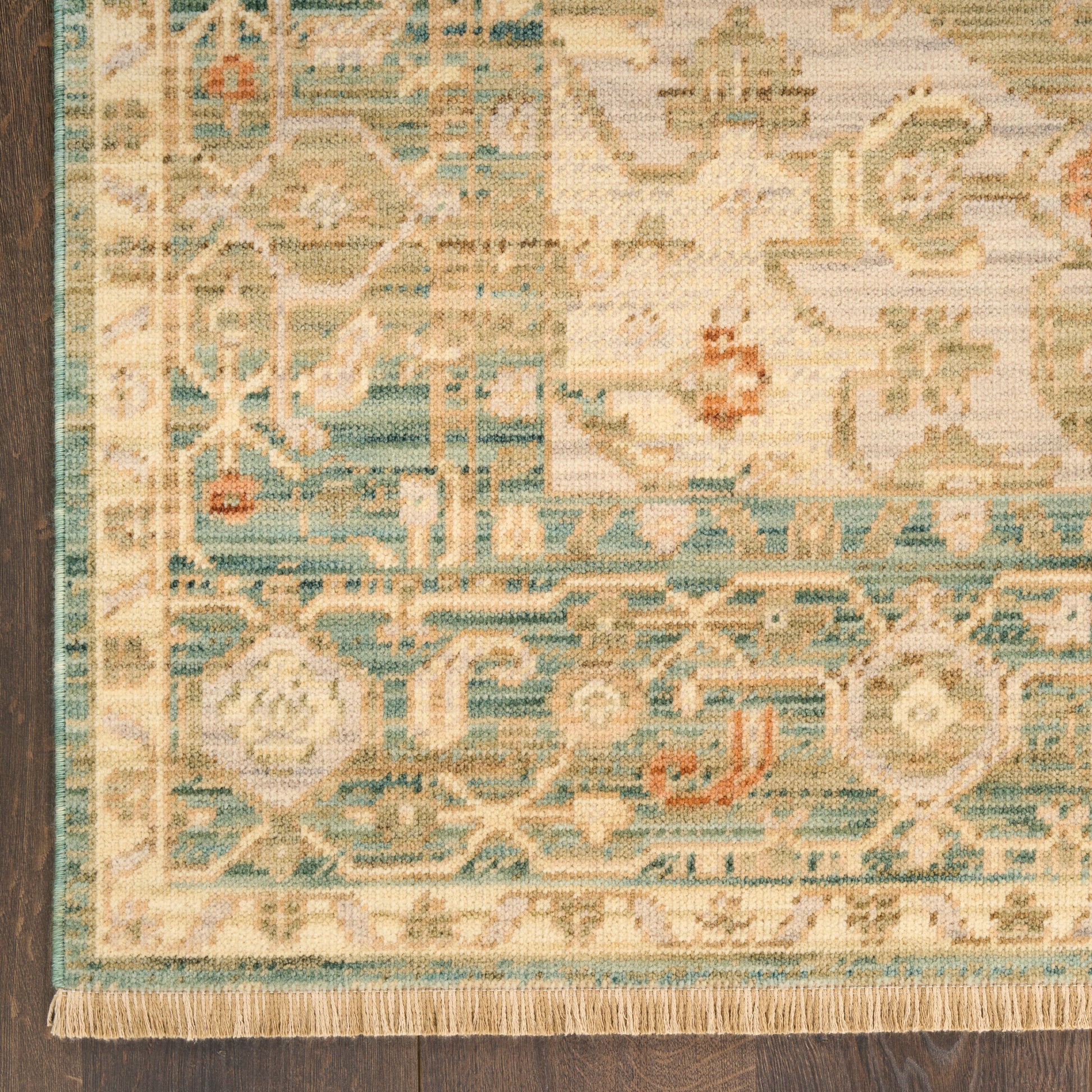 Rectangular Persian-style area rug with teal, ivory, and beige floral medallions and fringed edge.