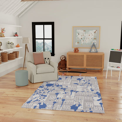 Rectangular kids' area rug in blue and white with a playful city/map graphic, laid in a bright kids' playroom.