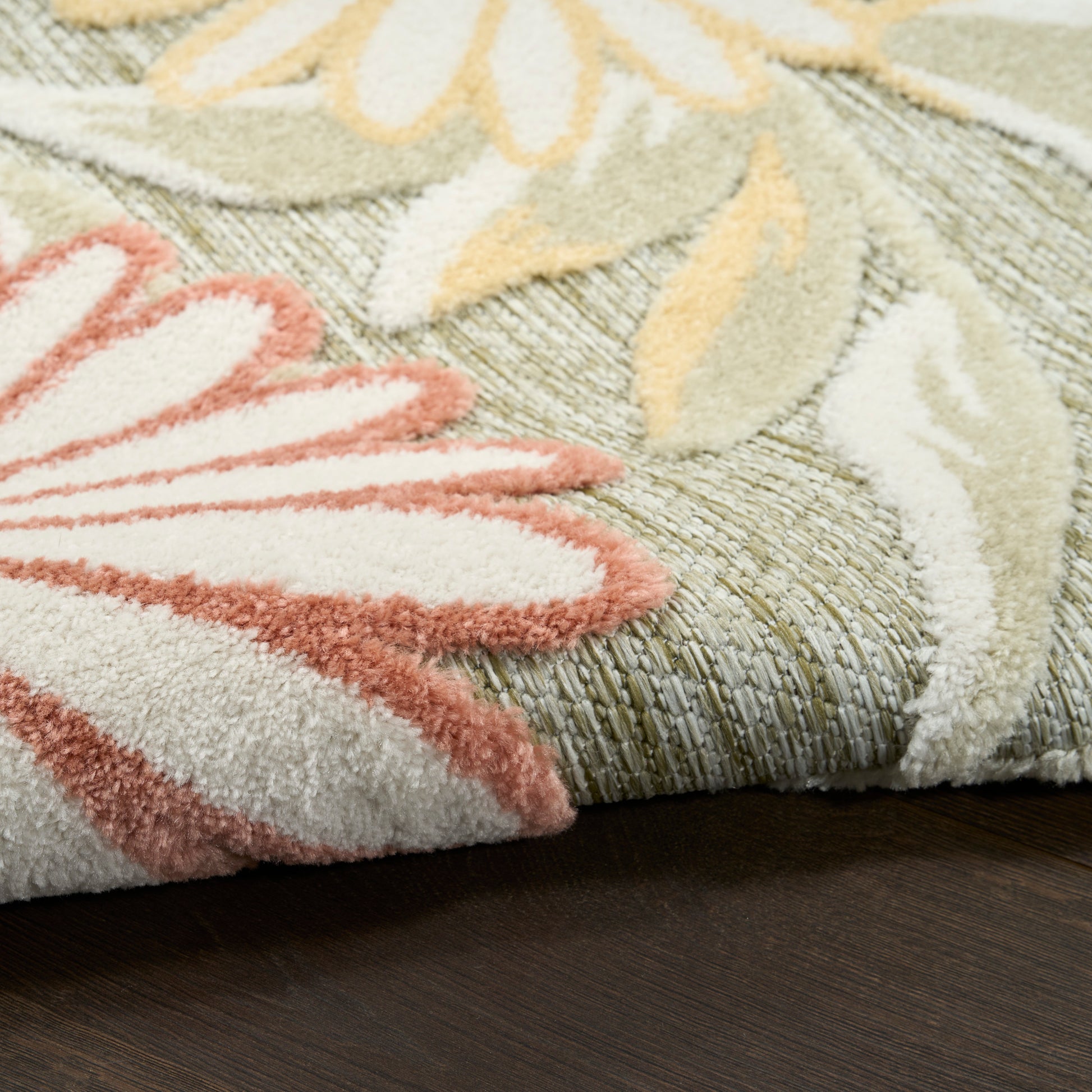 Pastel floral outdoor shag rug with pink petals on a sage-green background; cream and yellow leaves, plush pile.
