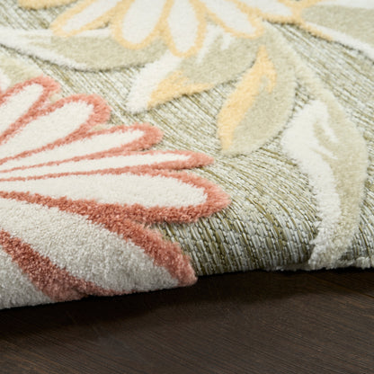 Pastel floral outdoor shag rug with pink petals on a sage-green background; cream and yellow leaves, plush pile.