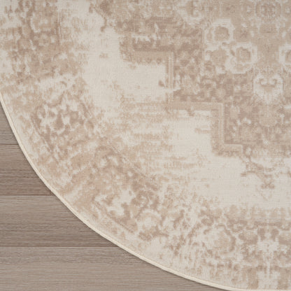 Beige round rug with a distressed vintage pattern on wood floor