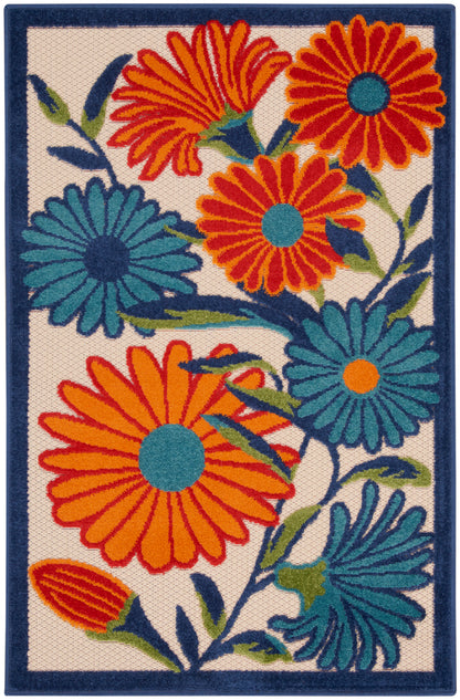 Rectangular woven rug with bold orange and teal daisy-like flowers on cream background, dark blue border.