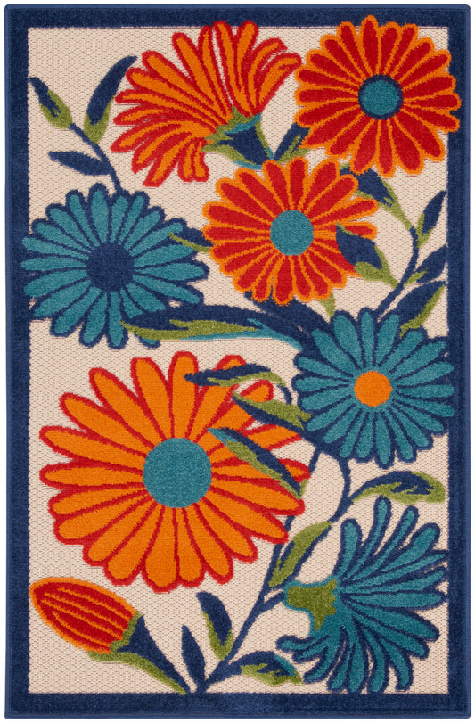 Rectangular woven rug with bold orange and teal daisy-like flowers on cream background, dark blue border.