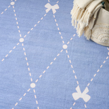 Blue rug with white dashed diamond pattern and a beige fringed throw in the top-right corner.