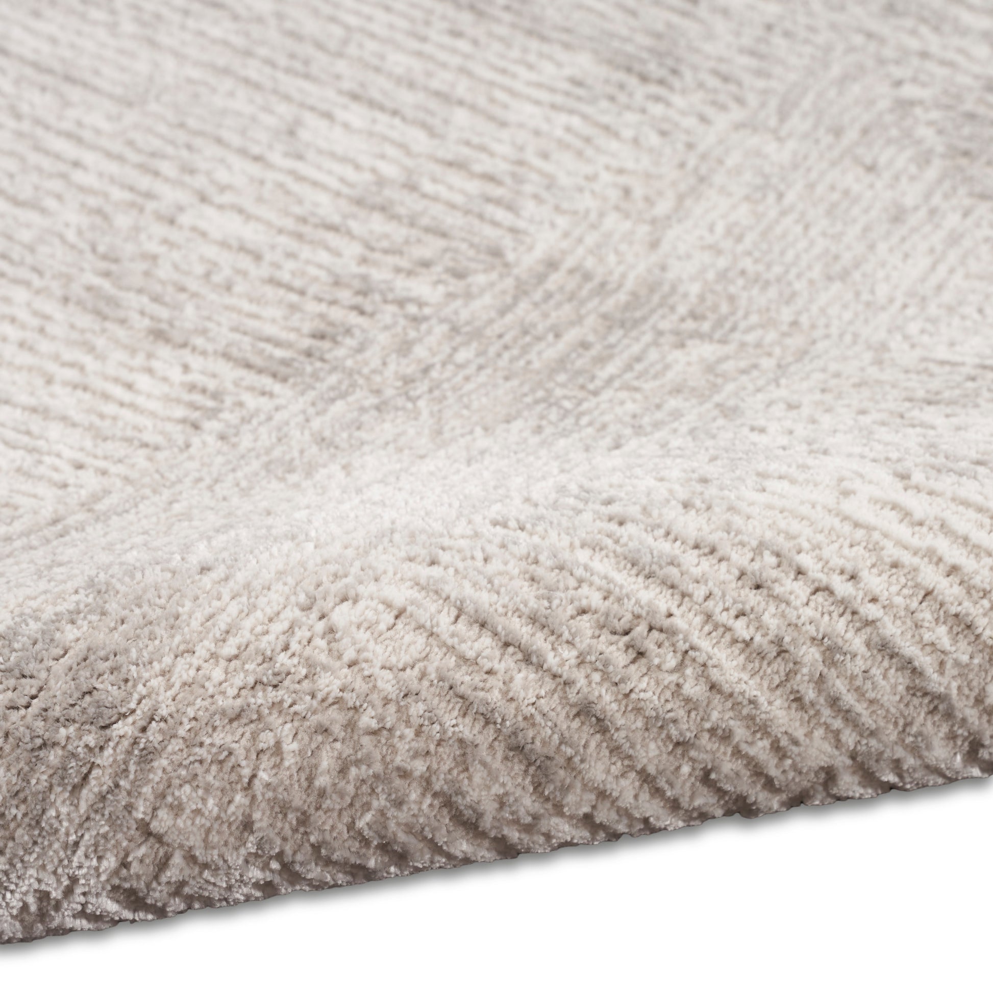 Beige shag rug close-up with soft fluffy pile and folded edge.