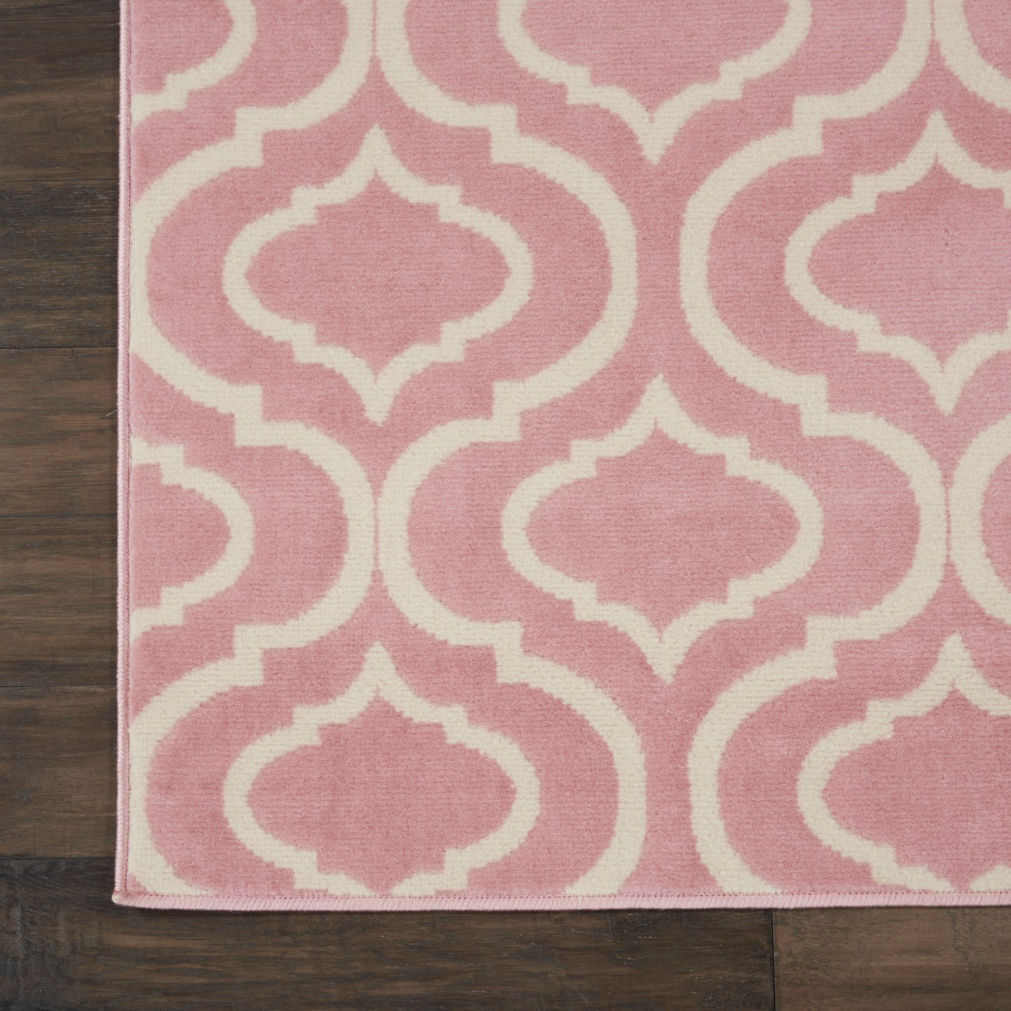 Pink rectangular rug with white trellis lattice pattern, 7' x 10'.