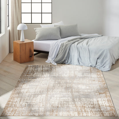 Minimalist bedroom with light gray bedding, white sheets, gray pillows, wooden cube nightstand, white lamp, and beige rug.