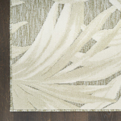Ivory palm-leaf patterned rug with cream motif on a gray-beige base, fringed edges, ideal for living room floors.
