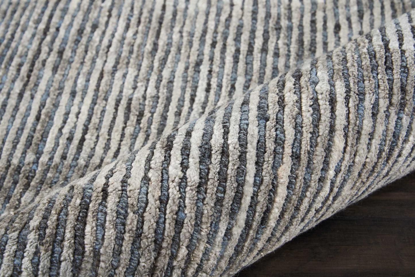Blue and gray striped plush rug with ribbed texture.
