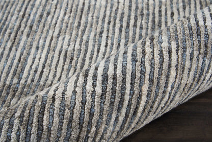 Blue and gray striped plush rug with ribbed texture.