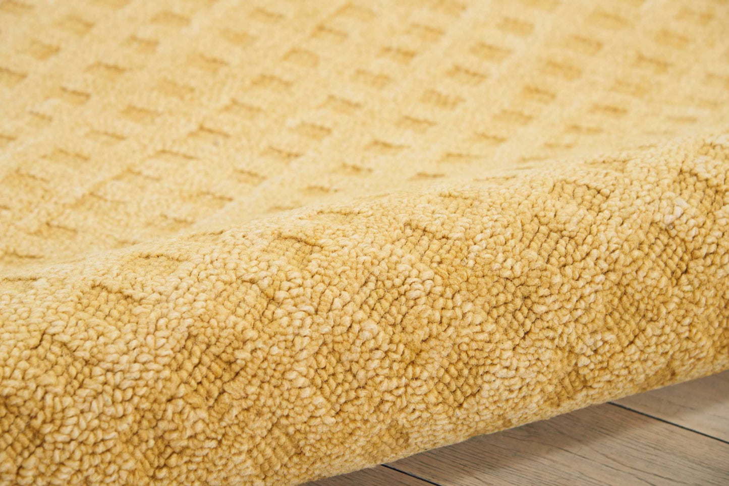 Mustard-yellow shag rug with dense plush pile on wooden floor.