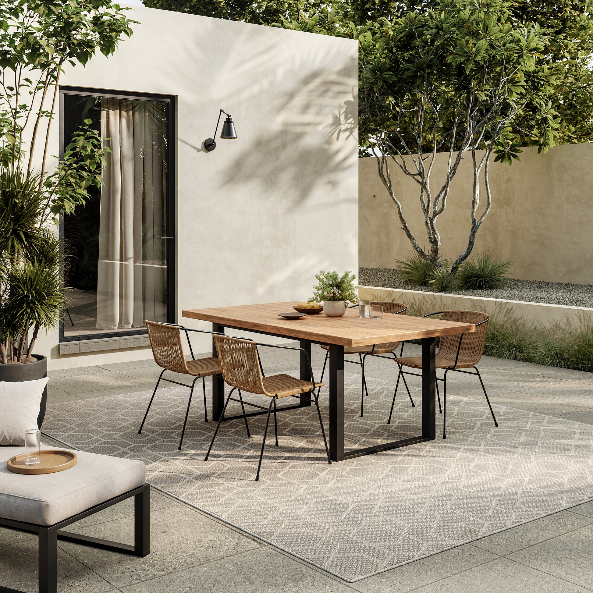Geometric outdoor rug, 10' x 14', shown on a patio with greenery.
