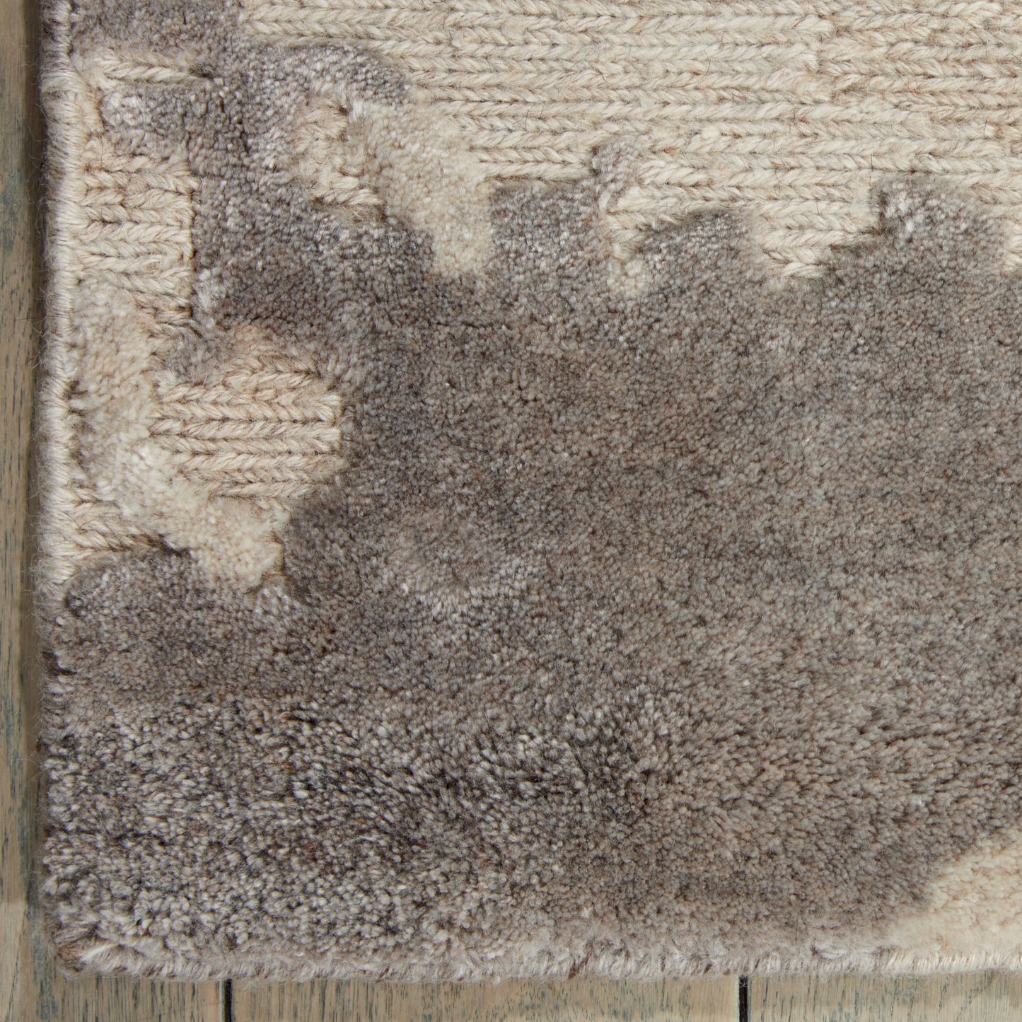 Close-up of a plush taupe and beige shag rug with cream accents and a soft high-pile texture.