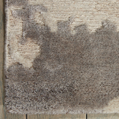 Close-up of a plush taupe and beige shag rug with cream accents and a soft high-pile texture.