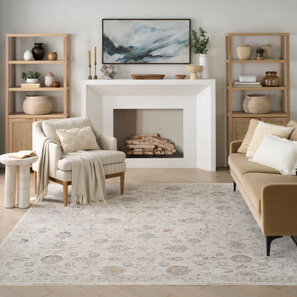 Neutral living room with white fireplace, beige sofa, cream armchair, light wood shelves, woven baskets, patterned rug.
