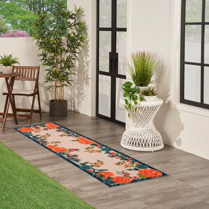 Floral runner rug with orange roses and blue border in a sunlit outdoor patio with potted plants.