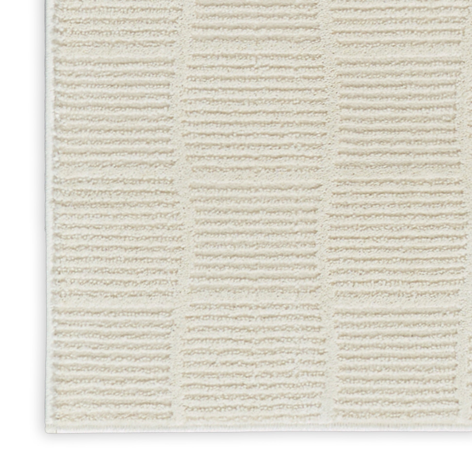 Cream textured bath mat with a grid of tufted rectangular blocks; plush bathroom rug.