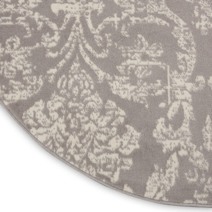 Round taupe rug with ivory damask pattern and woven texture for stylish living room decor.
